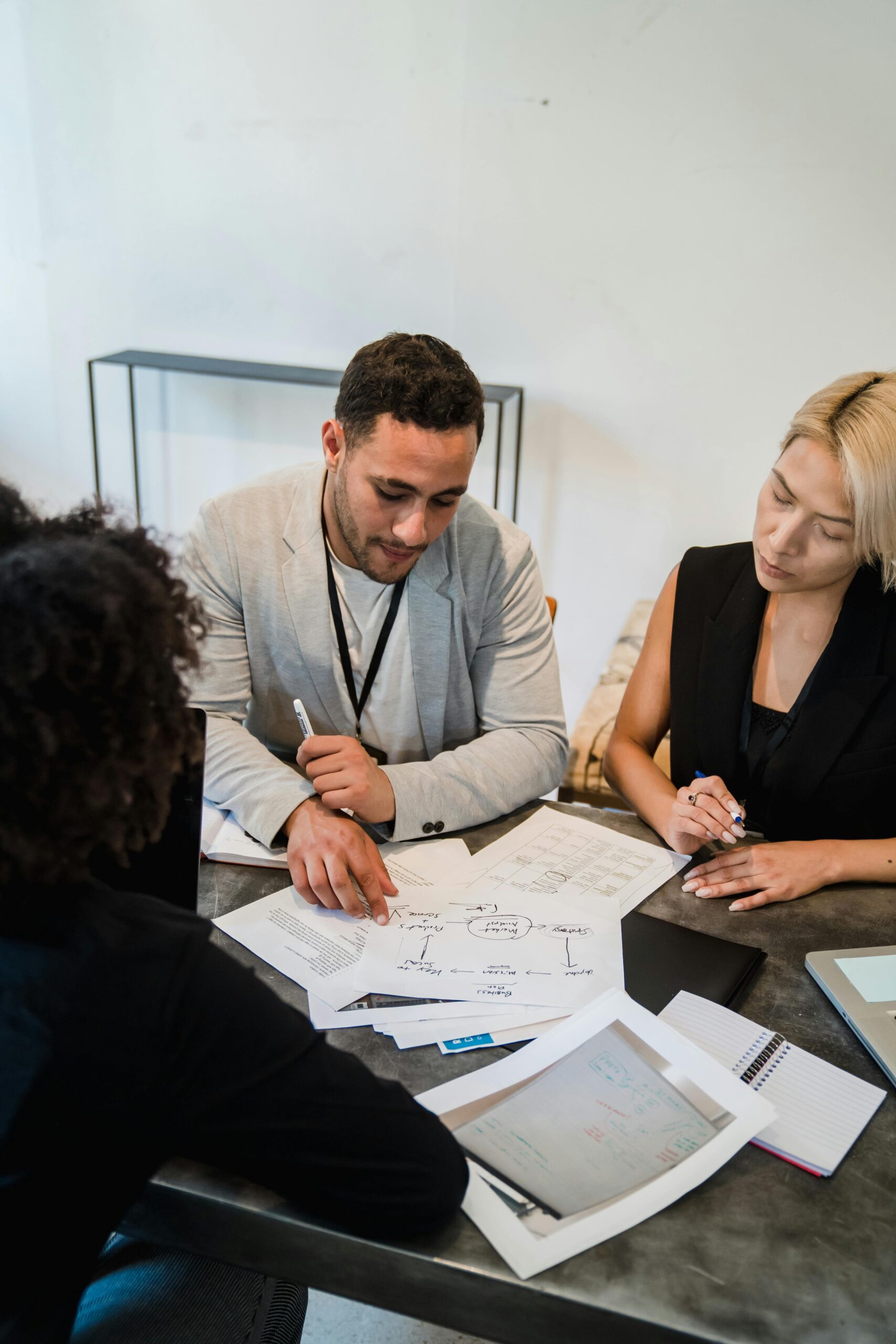 Diverse team engaged in collaboration, reviewing documents at an office desk.